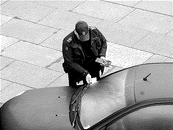 parking enforcement officer putting ticket under windshield wiper